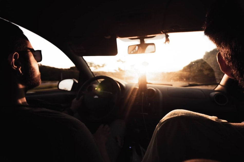 Drivers facing bright sunlight during drive home at sunset.