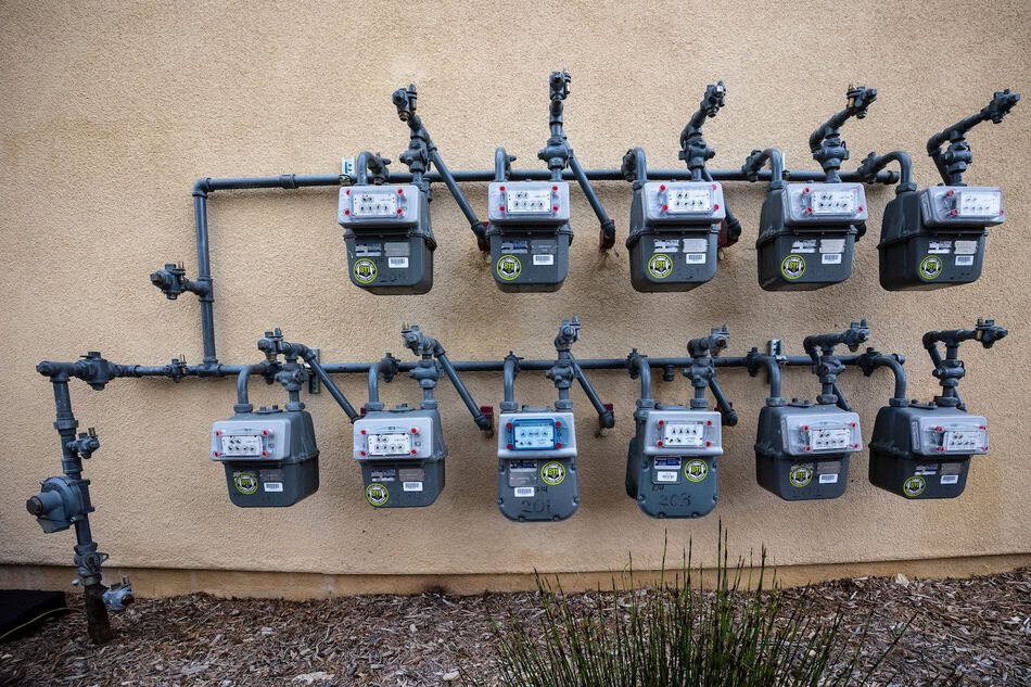 Multiple gas meters installed on a wall for home heating system.