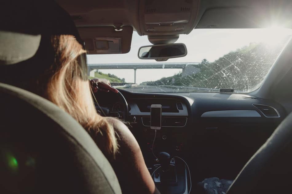 Driver experiencing blinding sunlight on the road during daytime.