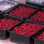 Baskets of ripe red cranberries at a farmers' market.