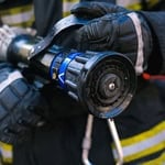 Firefighter inspecting a power tool for safe use during fire prevention.
