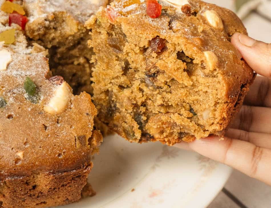 Close-up of a slice of fruitcake with nuts and candied fruit.