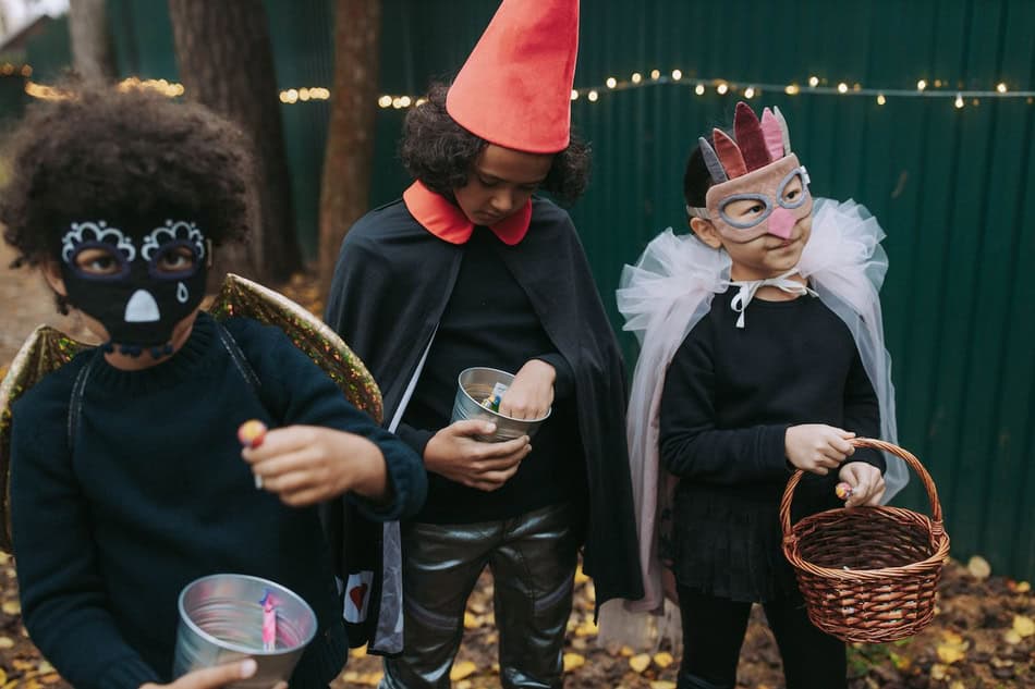 Children dressed in Halloween costumes with masks and accessories.